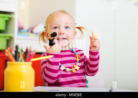 Adorable toddler girl playing with finger puppets Stock Photo