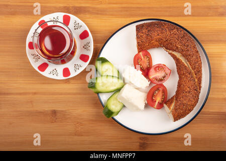 Breakfast with feta cheese,  simit, cucumber, cherry tomoto and tea isolated on wooden background top view Stock Photo
