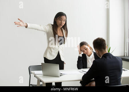 Mad HR representative pointing at door asking candidate to leave Stock Photo