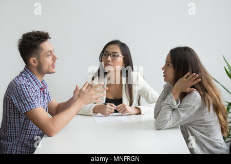 Nervous couple arguing in psychologist office Stock Photo