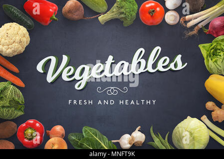 Fresh and healthy vegetables text on dark surface surrounded with vegetables. Stock Photo
