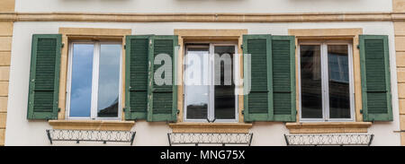 close up view of three windows with wooden window shutters in green Stock Photo