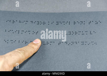 Top view of hand of a blind person reading a book written in braille alphabet for blind people.Copy space for editing.Istanbul,Turkey.10 February 2017 Stock Photo