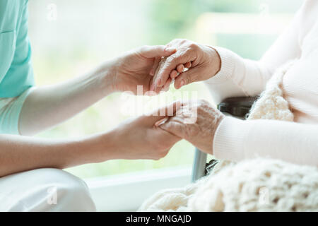 Photo of nurse holding her woman patient's hands with painted nails Stock Photo