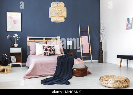 Round wicker footrest placed on the floor in stylish hotel room Stock Photo