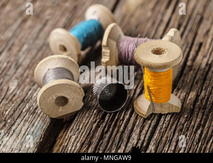 colored threads and thimble on wooden background Stock Photo