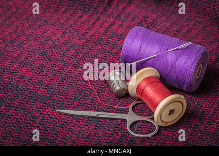 spools of colored threads against the background of knitted fabric Stock Photo