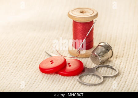 coils of colored thread on white knitted fabric Stock Photo