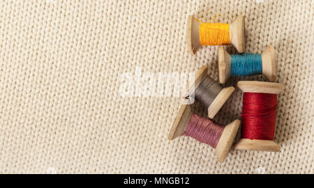 coils of colored thread on white knitted fabric Stock Photo