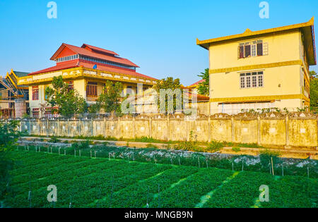 The large Buddhist monastic complex is neighboring with kitchen gardens, stretching by the railroads, Kyauk Myaung (East) Ward, Tamwe Township, Yangon Stock Photo