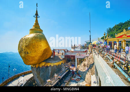 KYAIKTIYO, MYANMAR - FEBRUARY 16, 2018: The holy site of Golden Rock with numerous pilgrims and tourists, visiting Kyaiktiyo Pagoda, located on the mo Stock Photo