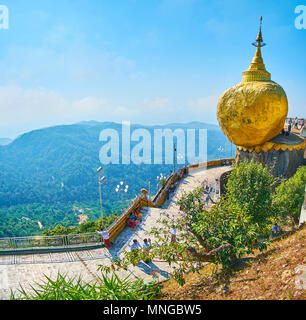 KYAIKTIYO, MYANMAR - FEBRUARY 16, 2018: The unique Buddhist shrine with Kyaiktiyo Pagoda on the top of the boulder, balancing at the edge of granite r Stock Photo