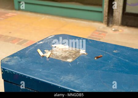 Cigarette butts left on top of bin as litter Stock Photo