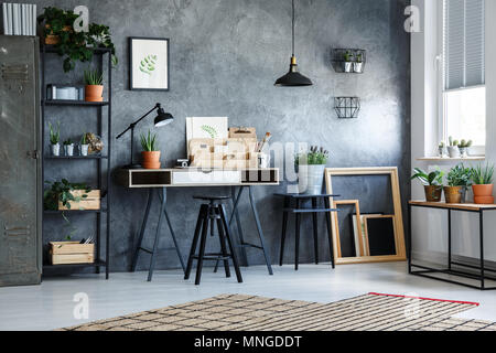 Functional office interior with desk, patterned carpet and plants Stock Photo