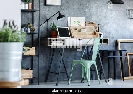 Turquoise vintage chair and desk in industrial room interior Stock Photo