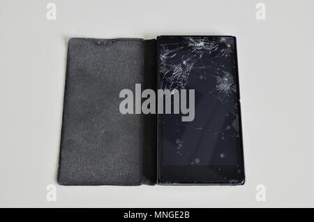 Cellphone screen with broken glass. Non-protecting the protective film glass is a web of glass splinters. Stock Photo
