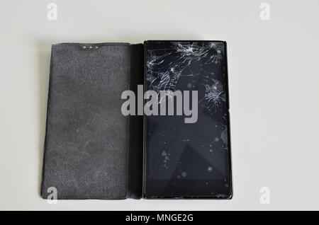 Cellphone screen with broken glass. Non-protecting the protective film glass is a web of glass splinters. Stock Photo