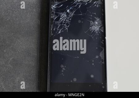 Cellphone screen with broken glass. Non-protecting the protective film glass is a web of glass splinters. Stock Photo