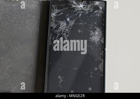 Cellphone screen with broken glass. Non-protecting the protective film glass is a web of glass splinters. Stock Photo