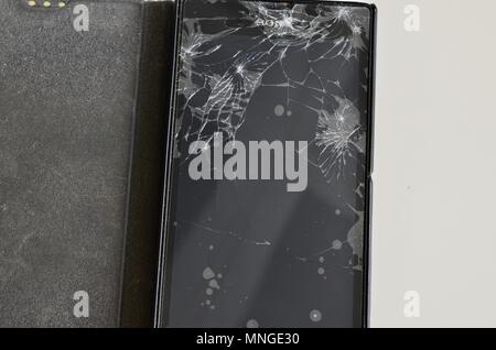 Cellphone screen with broken glass. Non-protecting the protective film glass is a web of glass splinters. Stock Photo