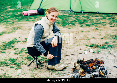 woman preparing marshmallow on campfire Stock Photo
