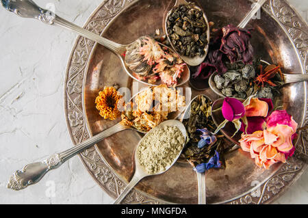 Various flavors of tea. Green tea flower tea matcha karkade in spoons in a vintage plate Stock Photo