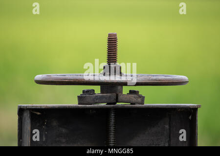 Iron wheel that opens a floodgate to  the water in the rice paddies of Thailand. Stock Photo