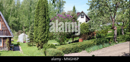 Beautiful  green spring  rural  garden with fruit trees and vegetable beds. Panoramic collage from several sunny day photos Stock Photo