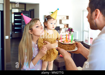 A family with a cake congratulates a happy child on his birthday Stock Photo