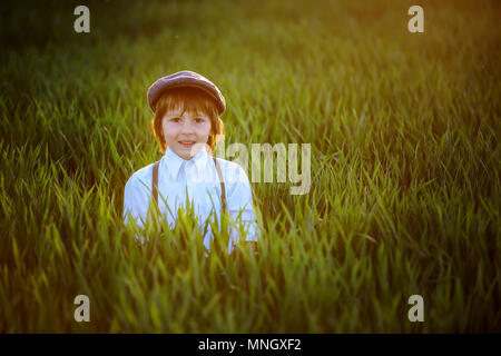 Portrait of child playing with bow and arrows, archery shoots a bow at the target on sunset Stock Photo