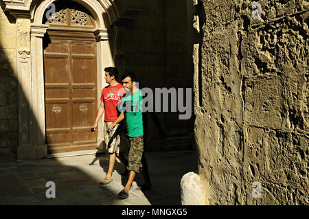 Two young men walking in the old town of Mdina, Malta Stock Photo