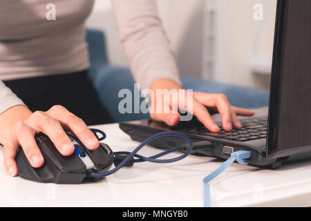 women hand is using the USB mouse while working on laptop Stock Photo
