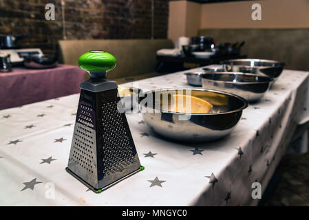 Close up metal grater with handle on kitchen table at cooking workshop Stock Photo