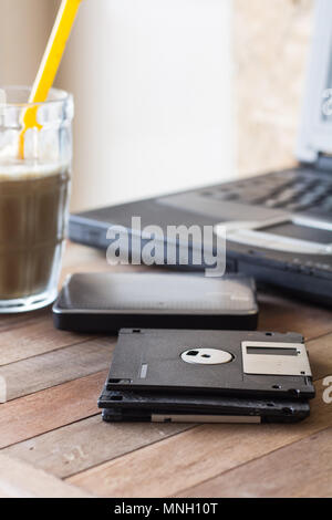 diskette on blur coffee in cup and blur notebook background, Stock Photo