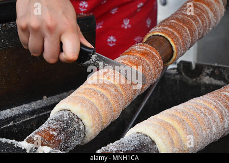 Close up sweet Trdelnik baking on grill, this spit cake is popular in Europe, Austria, Hungary, Slovakia and Czech, especially in Prague Stock Photo