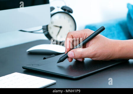 Focus on the busy graphic designer working on computer by digital pen mouse Stock Photo