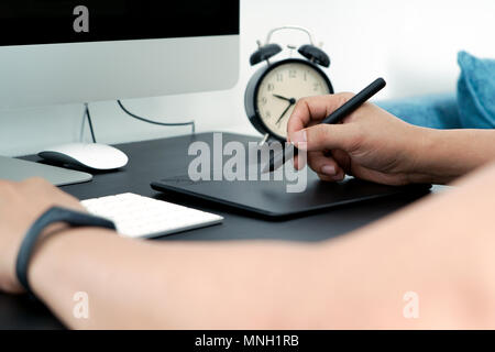 Focus on the busy graphic designer working on computer by digital pen mouse Stock Photo
