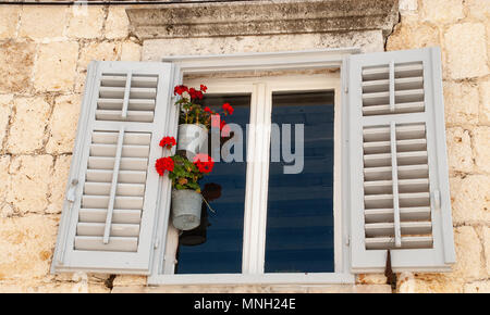 Window with Wooden Shutters and flowers Stock Photo