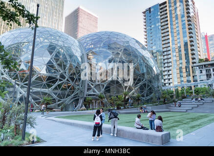 The Amazon company world headquarters in Seattle Washington afternoon sun, many people enjoying the campus lawn next to the Spheres. Stock Photo