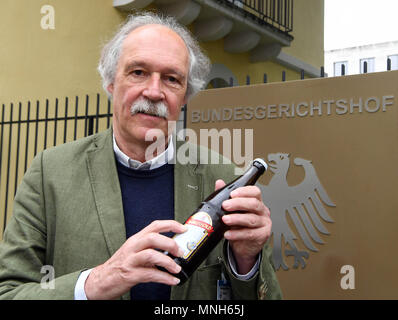 17 May 2018, Germany, Karlsruhe: Gottfried Haerle, manager of the Clemens Haerle brewery, holding a bottle of beer featuring the word 'bekoemmlich' outside the German Federal Court of Justice. The German Federal Court of Justice (BGH), is the hearing the case of whether a small brewery is allowed to describe its beers as 'bekoemmlich'. Photo: Uli Deck/dpa Stock Photo