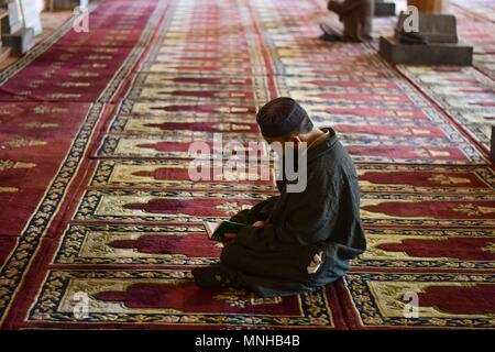 A Kashmiri man recites the Holy Quran inside the shrine of Syed Abdul ...