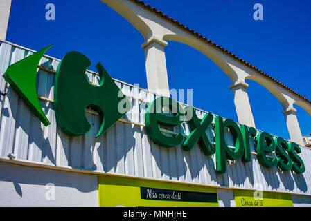 Express, the small local brand of Carrefour. Carrefour Express brand logo in Guardamar del Segura, Spain. Blue sky. French multinational Stock Photo