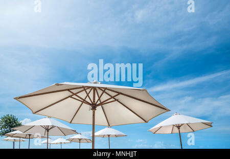 The beach umbrellas against the blue sky, sun parasols, thatched parasols Stock Photo