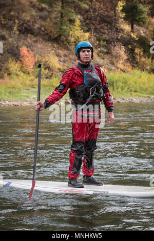 Man standing on stand-up paddleboard on Snake River and looking at camera, Jackson, Wyoming, USA Stock Photo