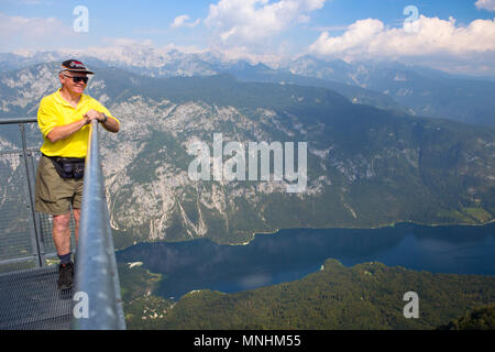 Man enjoying view over lake Bohinj, from mount Vogel, largest permanent lake located in Bohinj Valley of Julian Alps, Triglav National Park, Slovenia Stock Photo