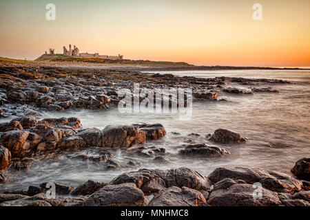 Sunrise at Dunstanburgh Castle on the Northumberland coast, North East England. Stock Photo