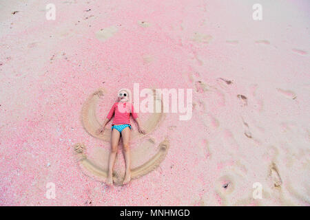 Girl making angel in sand on beach, high angle view Stock Photo - Alamy