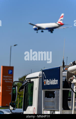 Vitol Aviation fuel tanker, with British Airways jet plane airliner coming in to land at London Heathrow Airport UK in blue sky Stock Photo