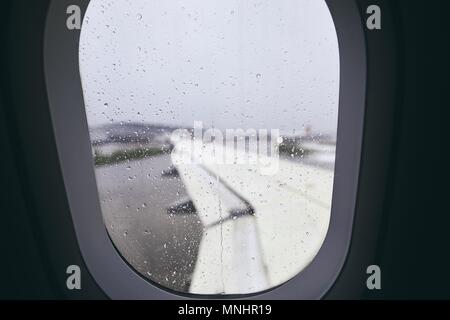 Close-up of airplane window during rain. Selective focus on raindrops. Stock Photo