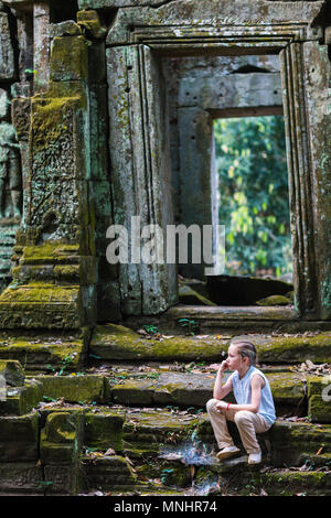 Little girl in ancient Angkor Wat temple in Siem Reap,  Cambodia Stock Photo